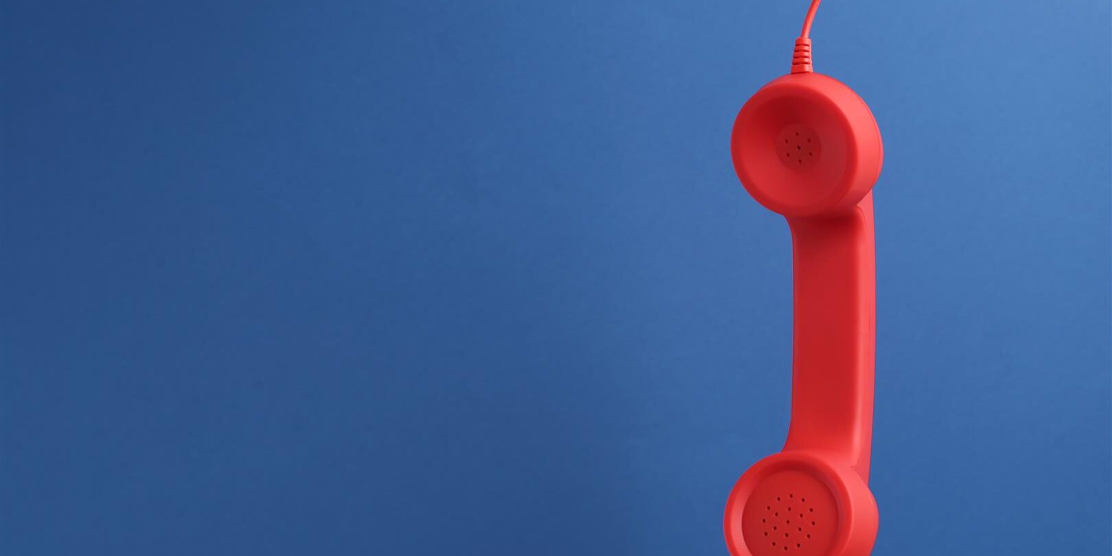 red corded telephone handset hanging on blue backg 2026 01 13 02 35 38 utc