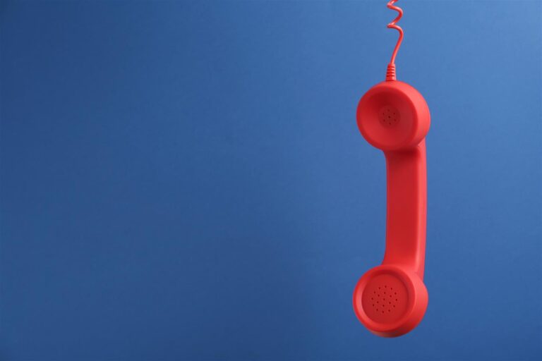 red corded telephone handset hanging on blue backg 2026 01 13 02 35 38 utc